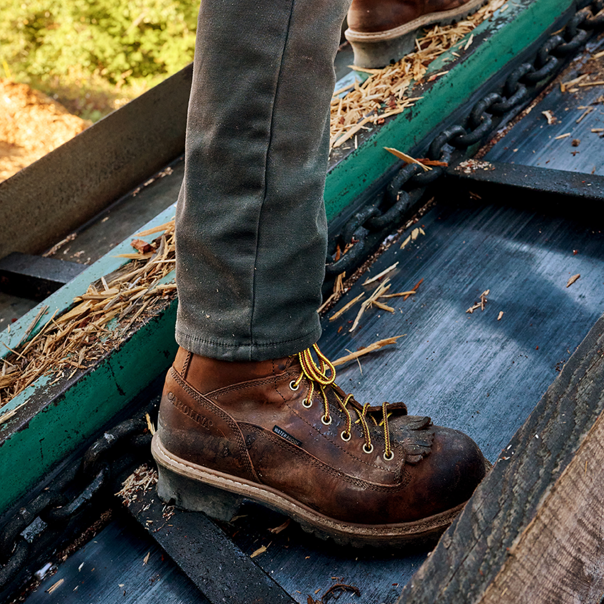 A man wearing Carolina shoes on a job site.