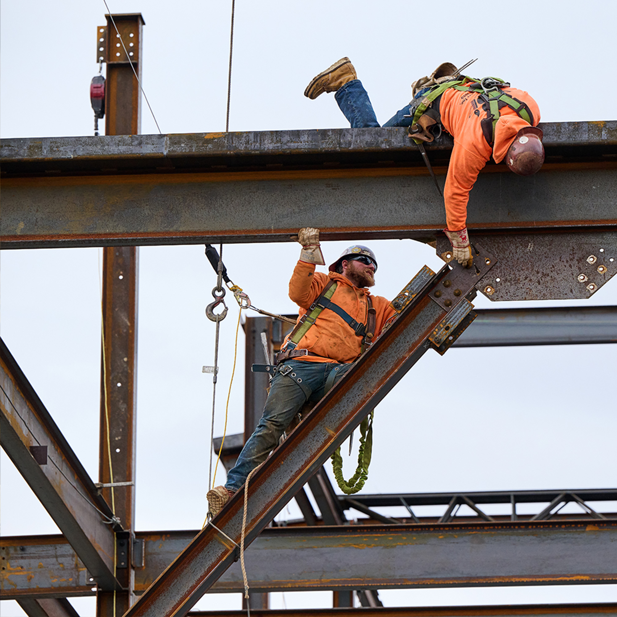 Two men working on a scaffolding wearing Carolina work boots.