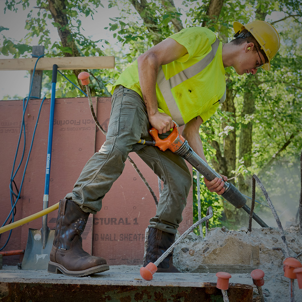 A worker wearing the Pipeline Comp Toe boot in brown.