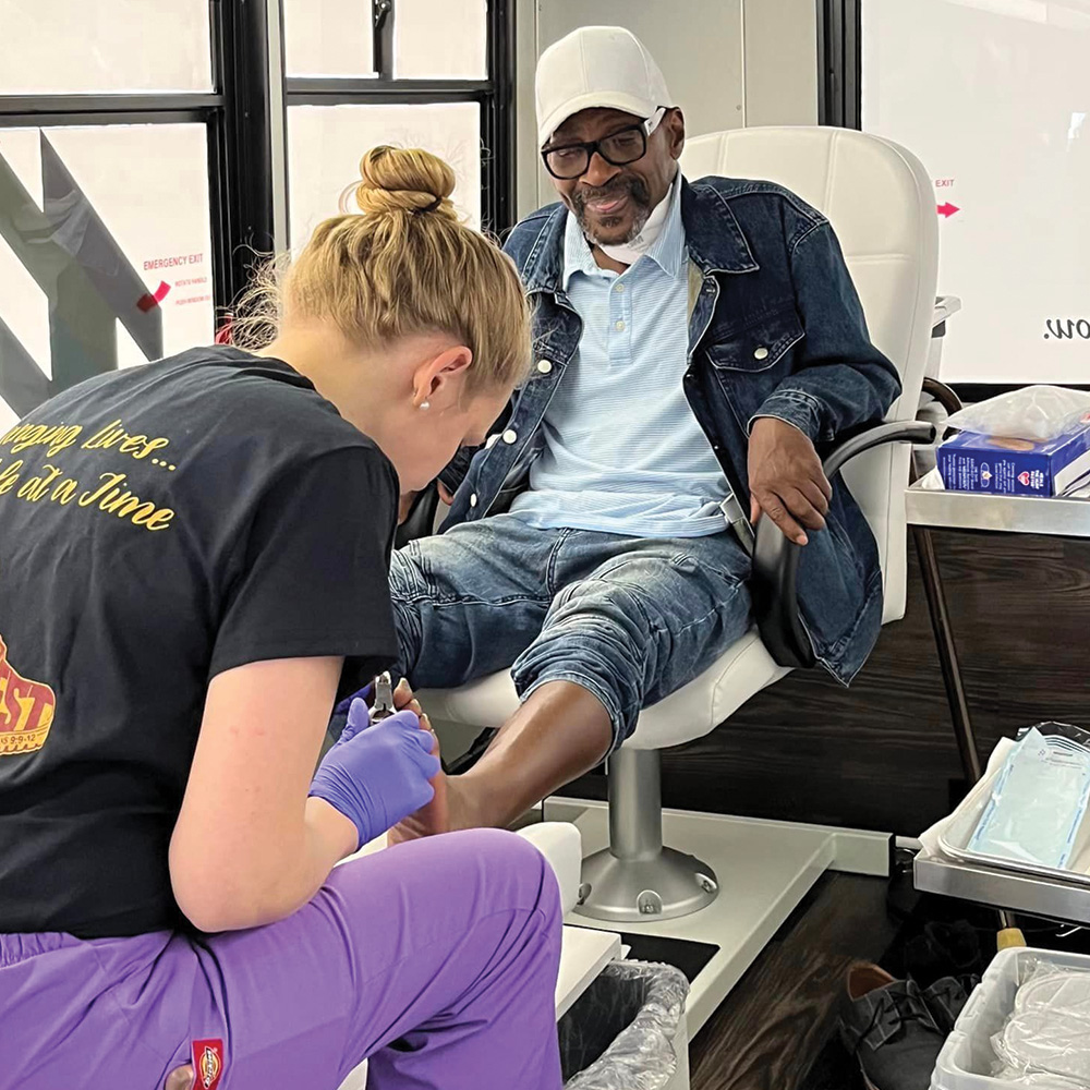 A man having his feet cared for by a volunteer.