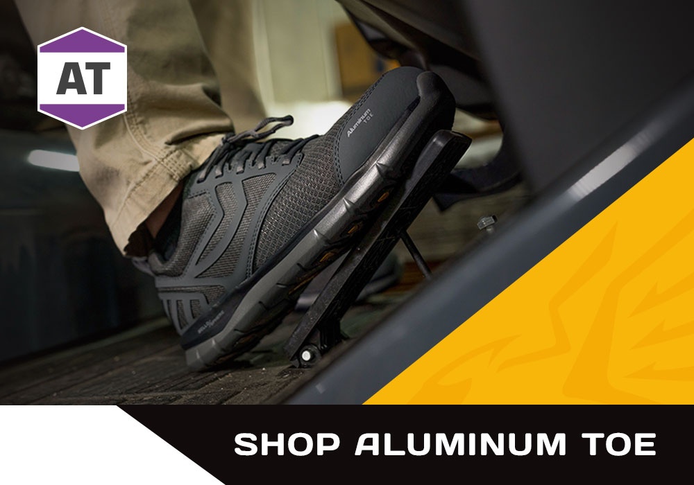 Shop aluminum toe. AT feature badge. A man working wearing the Gust Lo Aluminum Toe Work Shoe in black. Shop men's aluminum toe.